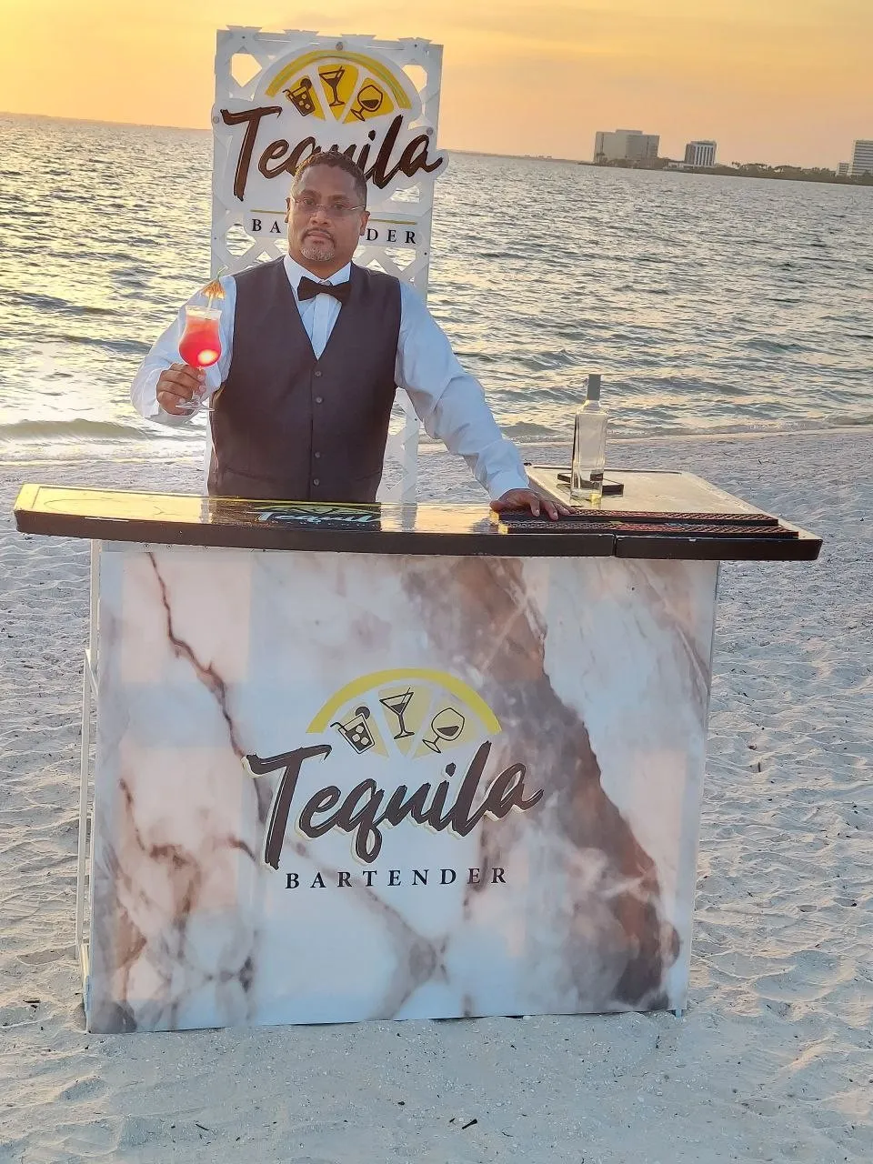 Bartender de Tequila Bartender junto a la barra móvil en la playa